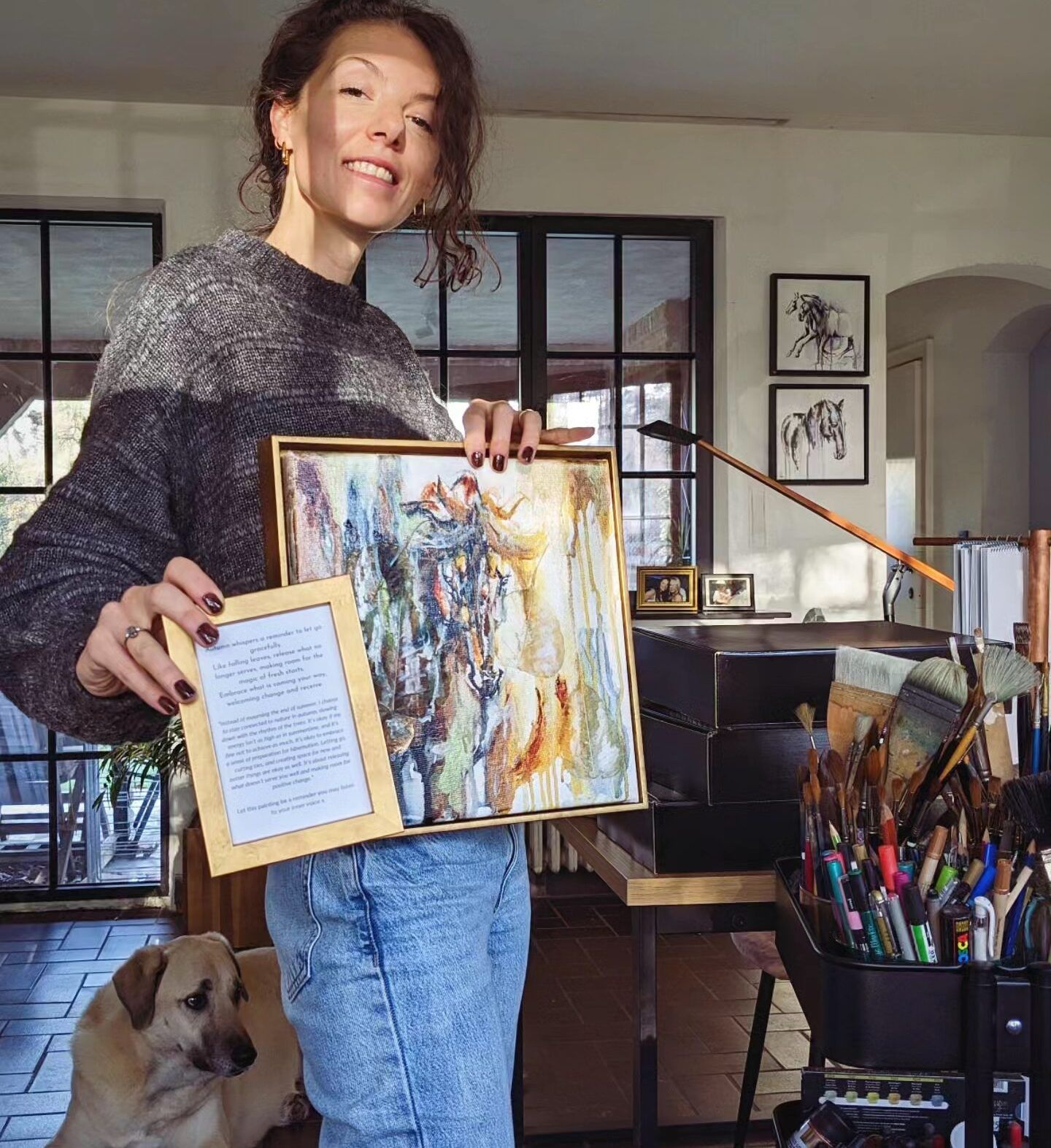 Marjo Lebbe in her studio holding a framed equine watercolour